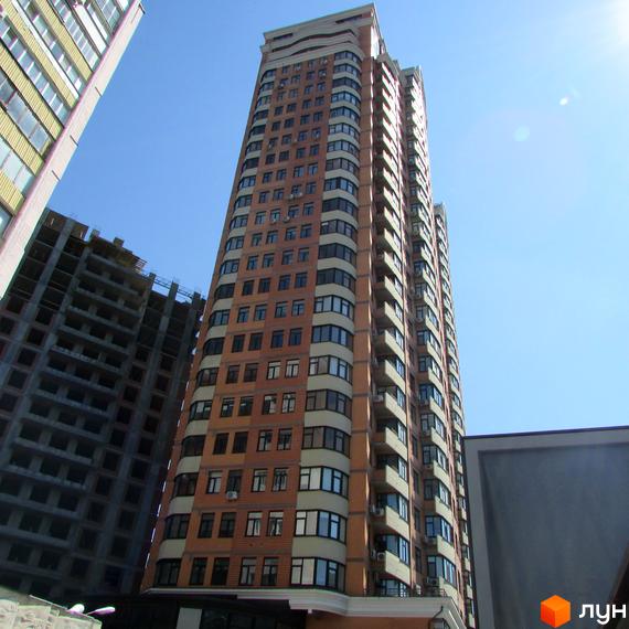 Житловий комплекс на бул. Лесі Українки, 7а, з висотним будинком та прибудинковою територією. Будівля з великими вікнами та балконами.