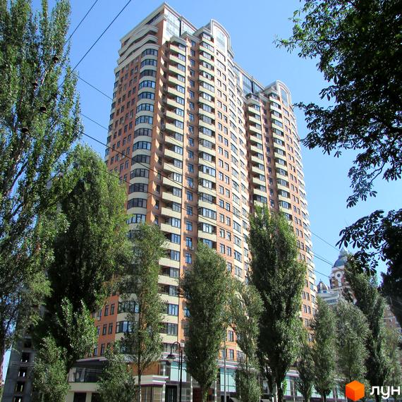 Житловий комплекс на бул. Лесі Українки, 7а, з багатоповерховою будівлею та зеленими насадженнями навколо.