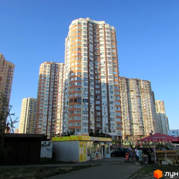 Житловий комплекс вул. Урлівська, будинок з балконами та фасадом у світлих тонах, прибудинкова територія з магазинами та відпочинковими зонами.