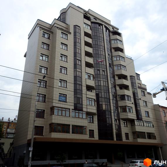 Фасад житлового комплексу на вул. Антоновича (Горького), 103, з великою кількістю скління та балконами. Будинок має багатоповерхову структуру з світлим оздобленням фасаду.