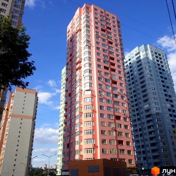 Новобудова на вул. Феодосійській, 2: високі будинки рожевого, блакитного та світло-сірого кольорів під блакитним небом.