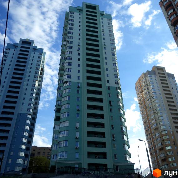 Житловий комплекс на вул. Феодосійській, 2: висотні будинки зі світлими фасадами. На фото видно кілька будівель та прибудинкову територію під хмарним небом.