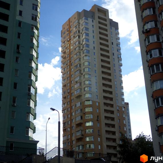 Високі житлові будинки світло-коричневого та бірюзового кольорів з численними вікнами та балконами. Вид на житловий комплекс на вул. Феодосійська, 2.