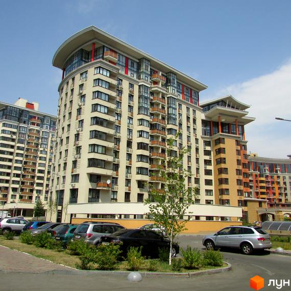 Житловий комплекс Сонячна брама з фасадами світлого кольору та вигнутим дахом. Перед будинками розташований паркінг та зелені насадження.