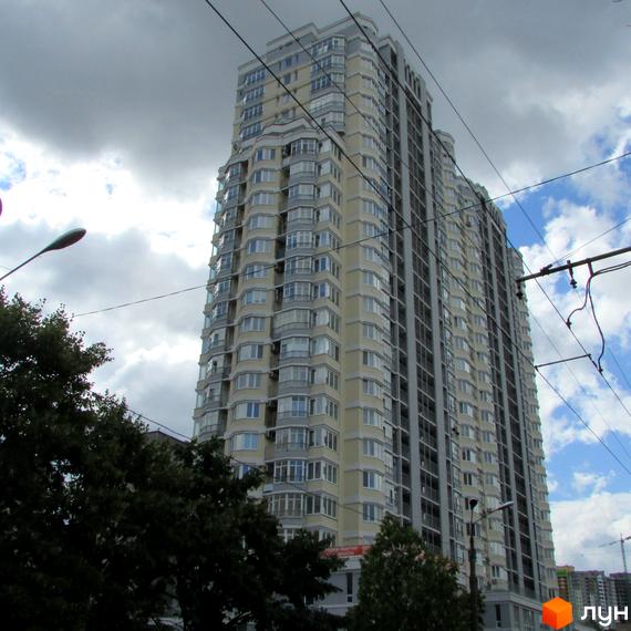 Багатоповерховий житловий комплекс на вул. Миколи Голего, 7в з бежевим фасадом та численними балконами, оточений зеленню дерев.