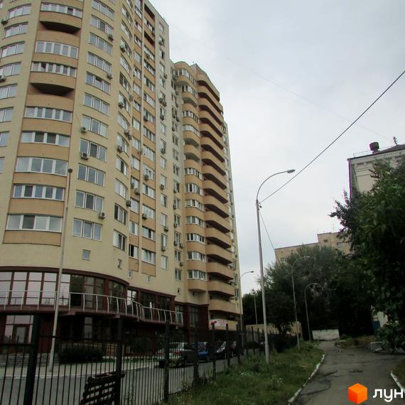 Житловий комплекс Ново-Деміївський з сучасним фасадом та прибудинковою територією, що включає зелені насадження.