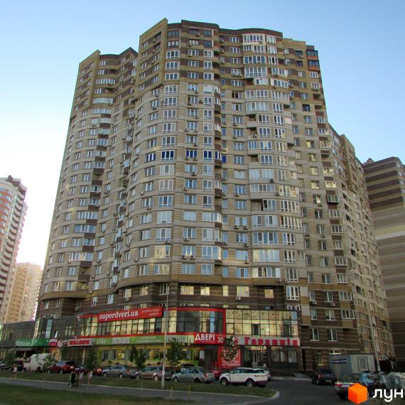 Житловий комплекс на вул. Ахматової, 30, з сучасною архітектурою та прибудинковою територією з зеленими насадженнями.