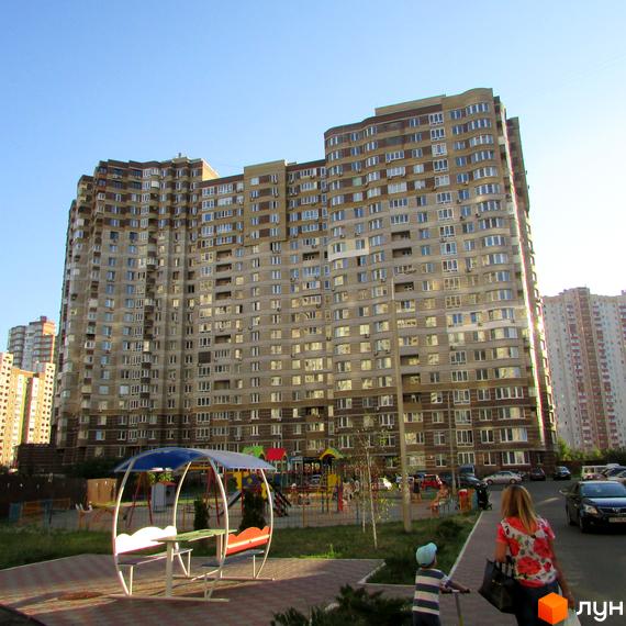 Житловий комплекс на вул. Ахматової, 30 з сучасною архітектурою та прибудинковою територією з дитячим майданчиком.