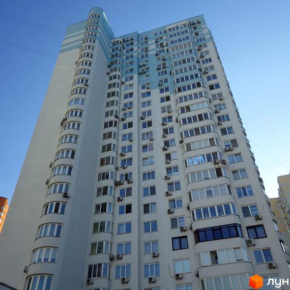 Вигляд житлового комплексу на вул. Єлизавети Чавдар з численними балконами та великими вікнами. Прибудинкова територія озеленена та облаштована.