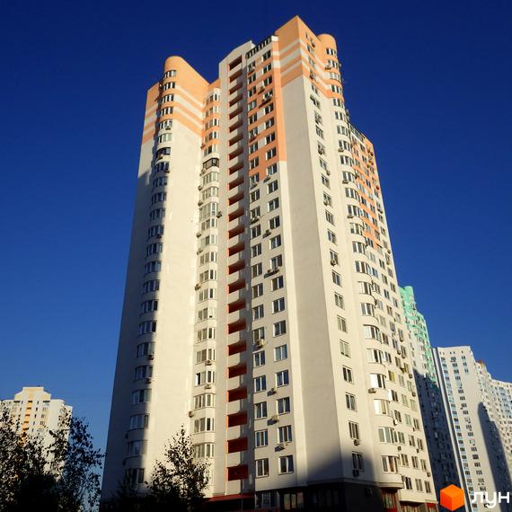 Житловий комплекс на вул. Єлизавети Чавдар, висотна будівля з великими вікнами та балконами, прибудинкова територія з зеленими насадженнями.