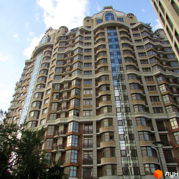 Житловий комплекс на вул. Богдана Хмельницького, 58а. Будинок з великими вікнами та прибудинковою територією, озелененою деревами.