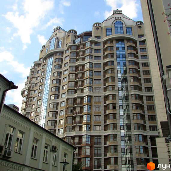 Житловий комплекс на вул. Богдана Хмельницького, 58а, з фасадом з великими вікнами. Прибудинкова територія з зеленими насадженнями та сучасним благоустроєм.