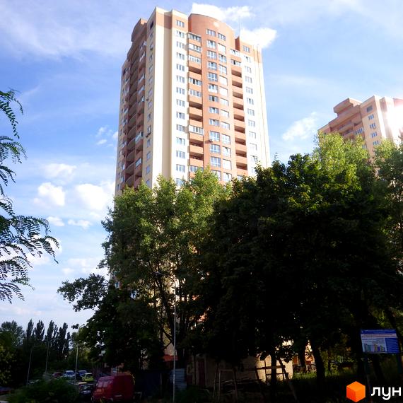 Житловий комплекс пров. Моторний, 9, 9а. Високий будинок оточений зеленими деревами та облаштованою прибудинковою територією.