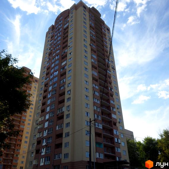 Висотний будинок житлового комплексу пров. Моторний, 9, 9а з балконами. Прибудинкова територія озеленена деревами та кущами.