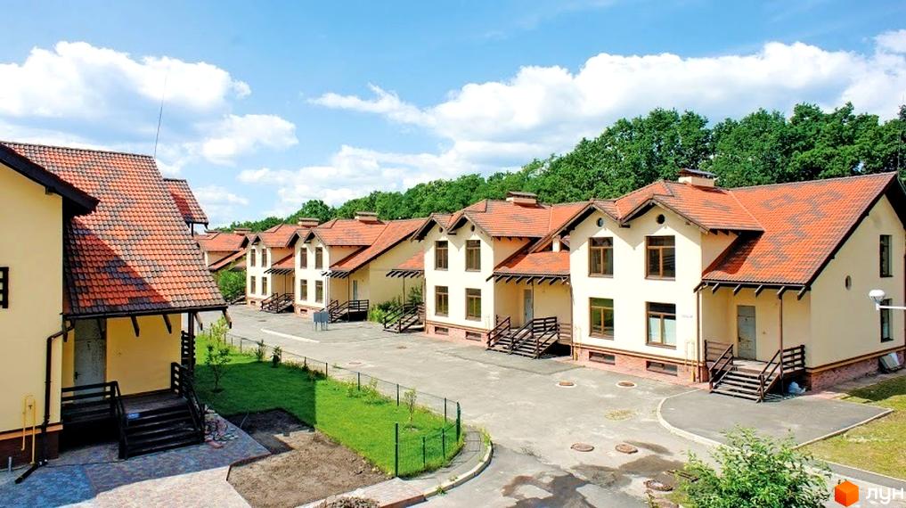 Котеджне містечко Садок Вишневий. Двоповерхові будинки з похилим дахом, терасами та сходами. На території є газон та асфальтована дорога.