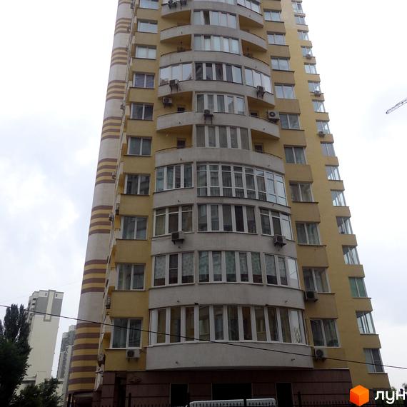 Житловий комплекс Затишний з фасадом, виконаним у світлих тонах, та великими вікнами. Прибудинкова територія озеленена та облаштована.