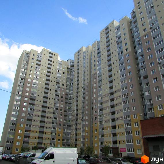 Житловий комплекс Милославичі з висотними будинками та прибудинковою територією, облаштованою для паркування.