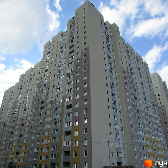 Житловий комплекс Милославичі з висотними будинками та облаштованою прибудинковою територією. Просторі фасади з великими вікнами.