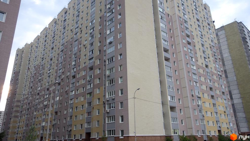 Житловий комплекс Милославичі з висотними будинками та прибудинковою територією. На фоні видно зелені насадження та дорогу.