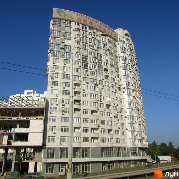 Житловий комплекс Park Stone - висотна новобудова з численними балконами та кондиціонерами на фасаді. На зображенні видно частину будівельного майданчика поруч.