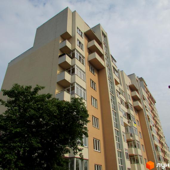 Житловий комплекс на вул. Петропавлівська, 50, 50б, з балконами та великими вікнами, оточений зеленими насадженнями.