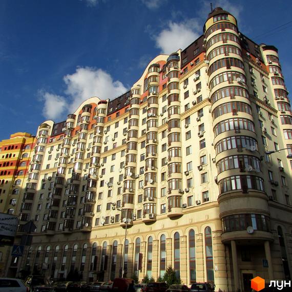 Житловий комплекс Златоустівський - багатоповерховий будинок з вигнутими фасадами та еркерними вікнами. Фасади оздоблені світлою штукатуркою та коричневими елементами.