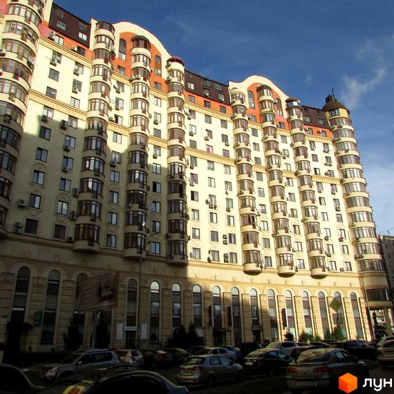 Житловий комплекс Златоустівський - це висотна будівля з багатоярусними балконами та арочними вікнами. Навколо будинку розташовані припарковані автомобілі.