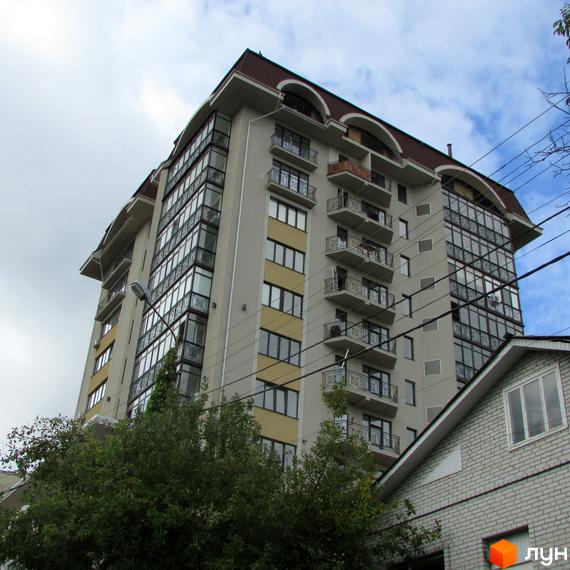 Житловий комплекс Нагірний з сучасним фасадом та великими вікнами, оточений зеленими насадженнями.