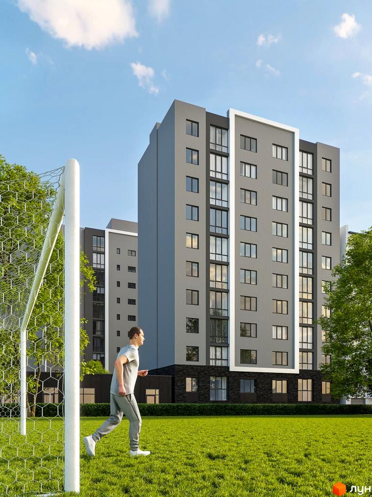 Новобудова Комфорт Сіті з сірими фасадами та великими вікнами, поруч футбольне поле з воротами та зелена галявина.