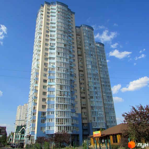 Житловий комплекс Озерні зорі з блакитними та бежевими фасадами, великою кількістю вікон та балконів. Навколо комплексу зелені насадження та невисока дерев'яна будівля ресторану.