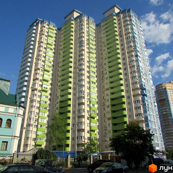 Житловий комплекс Озерні зорі - багатоповерхові будинки з яскравими зеленими та блакитними фасадами, балконами та кондиціонерами. На прибудинковій території дерева та припарковані автомобілі.