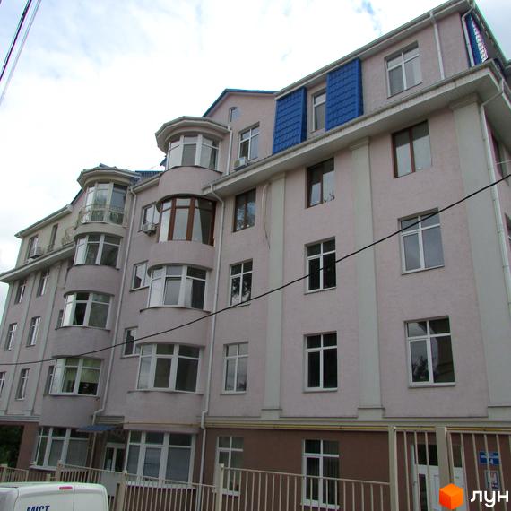 Фасад будинку житлового комплексу на пров. Іллі Рєпіна (Шишкінський) з численними вікнами та балконами. Поруч видно паркан та елементи прибудинкової території.