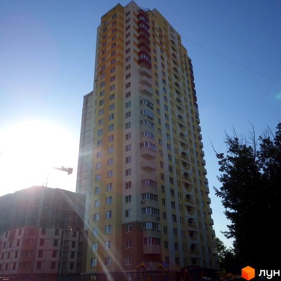 Високоповерховий житловий комплекс на вул. Хорольській, 1а, з фасадом жовто-білого кольору та балконами. Поруч видно будівельний кран та зелені насадження.