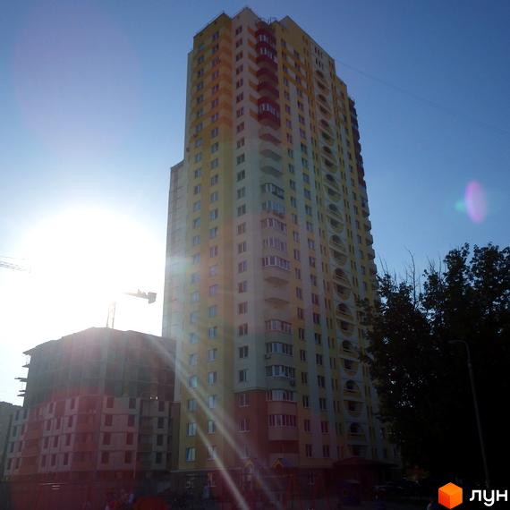 Високоповерховий житловий комплекс на вулиці Хорольській, 1а, з жовто-білим фасадом та балконами. Поруч видно будівельний майданчик іншої новобудови.