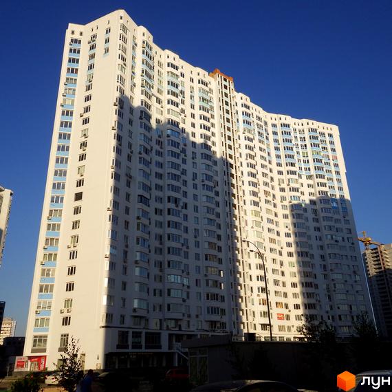 Фото фасаду житлового будинку по вулиці Єлизавети Чавдар, 13. Багатоповерхова будівля з великою кількістю вікон на фоні синього неба.