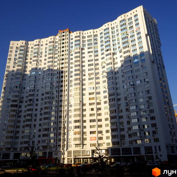 Зображення багатоповерхового будинку на вулиці Єлизавети Чавдар, 13. Вигляд фасаду та вікон житлового будинку на фоні блакитного неба.