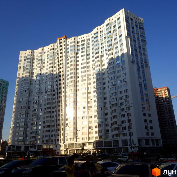 Зображення багатоповерхового будинку за адресою вул. Єлизавети Чавдар, 13. На передньому плані видно частину парковки з автомобілями.