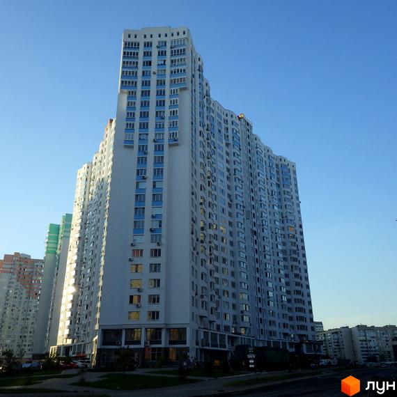 Зображення фасаду будинку по вулиці Єлизавети Чавдар, 13. Багатоповерхова будівля з великою кількістю вікон на тлі блакитного неба.