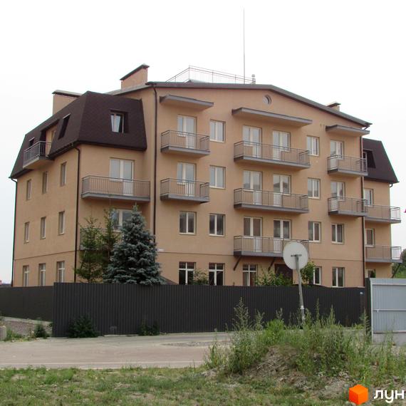 Зображення будинку в Житловому районі Цитадель „Теремки“. Багатоповерхівка з балконами, коричневим дахом та сірою огорожею.