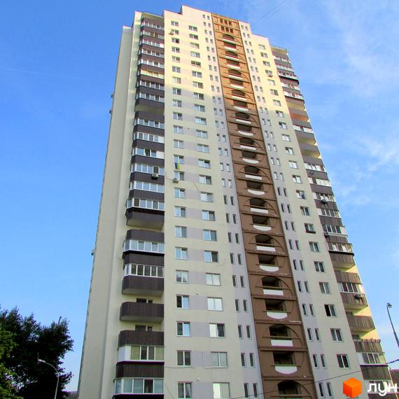 Висотна новобудова на вулиці Макаренка, 1а. Багатоповерховий будинок з балконами та панорамними вікнами на тлі блакитного неба.