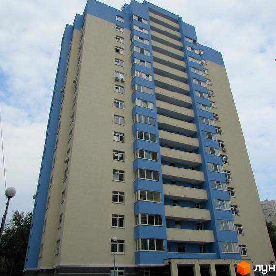 Багатоповерховий житловий будинок Житлового комплексу Паркові озера з бежевим фасадом та синіми балконами. На передньому плані видно частину вулиці та дерева.