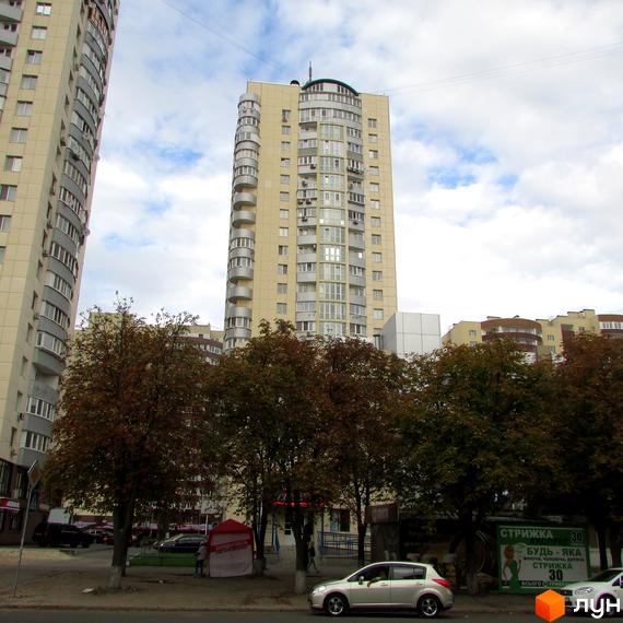 Житловий комплекс Парковий: високі будівлі світлого кольору з численними вікнами та балконами. Перед будинками розташовані дерева та дорога з автомобілями.