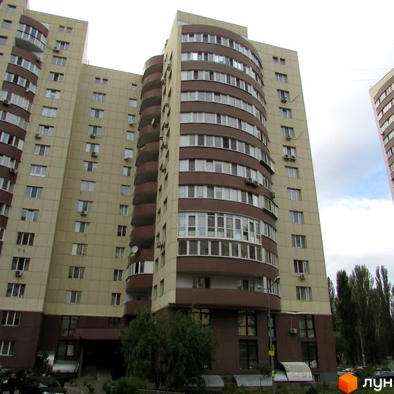 Багатоповерховий житловий комплекс Парковий з бежево-коричневим фасадом та вигнутими балконами. Перед будинком видно зелені насадження та припарковані автомобілі.