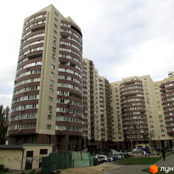 Зображення Житлового комплексу Парковий: багатоповерхові будинки з коричнево-бежевими фасадами та округлими балконами. Видно прибудинкову територію з парковкою.