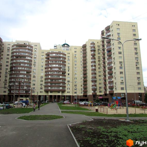 Житловий комплекс Парковий: багатоповерхові будинки світлого кольору з коричневими балконами та дитячий майданчик у дворі.
