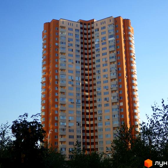 Житловий комплекс Молодіжний квартал з яскравими фасадами. Прибудинкова територія озеленена деревами та кущами.