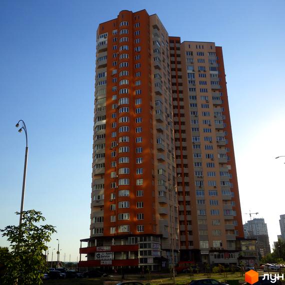 Житловий комплекс Молодіжний квартал з висотним будинком та прибудинковою територією, облаштованою парковкою та зеленими насадженнями.