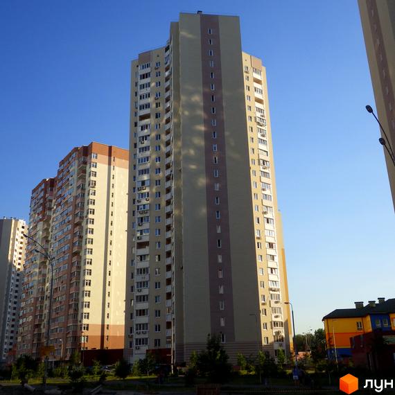 Висотні будинки житлового комплексу Молодіжний квартал з сучасним фасадом. Прибудинкова територія з зеленими насадженнями та доріжками.