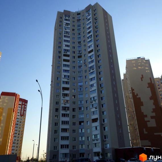 Житловий комплекс Молодіжний квартал з висотними будинками та прибудинковою територією. Вид на фасад з балконами та вікнами.