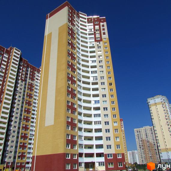 Житловий комплекс Молодіжний квартал з висотними будинками та просторими балконами. Прибудинкова територія з зеленими насадженнями.